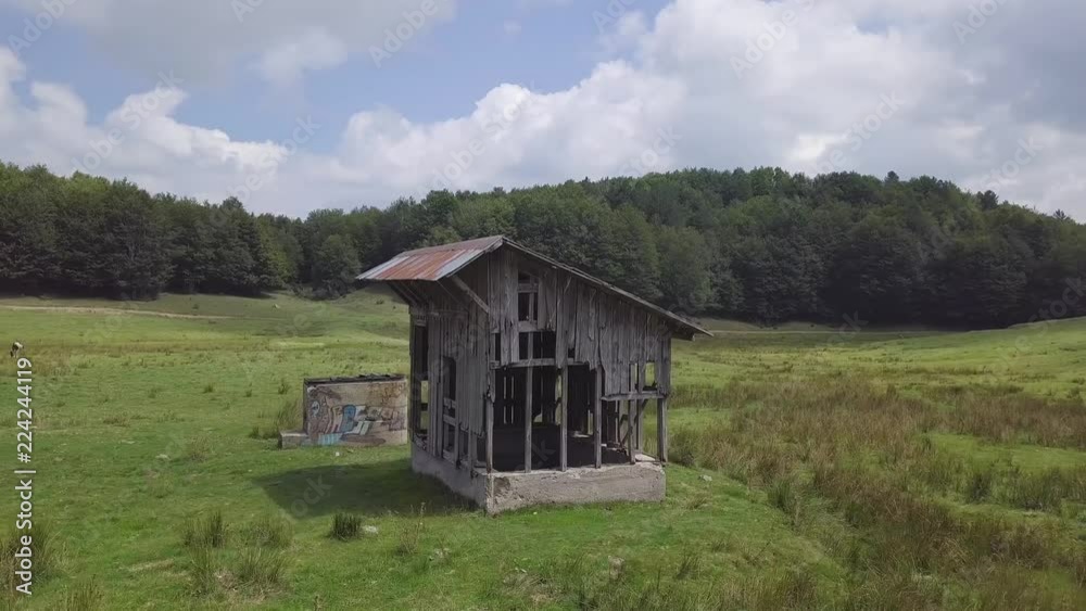 4k low angle orbit drone aerial of wooden hut on green highlands, by a forest 4k low angle orbit drone aerial of wooden hut on green highlands, by a forest