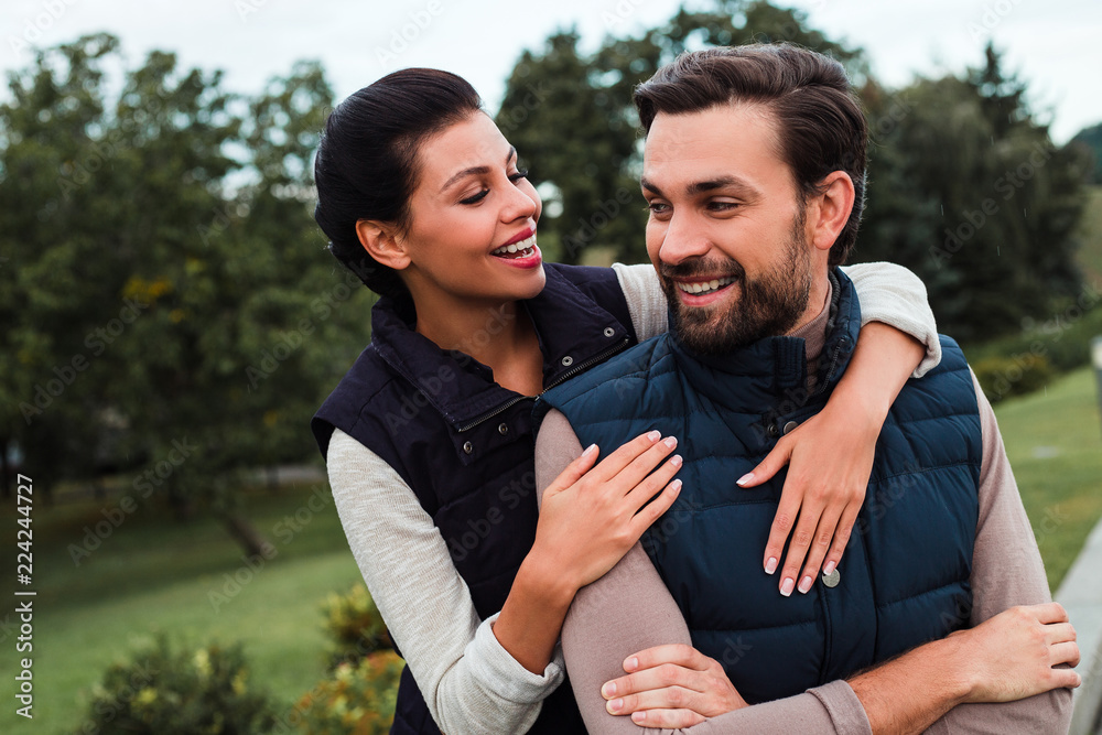 Fototapeta premium Love season. Young beautiful couple bonding to each other while walking in the park in autumn