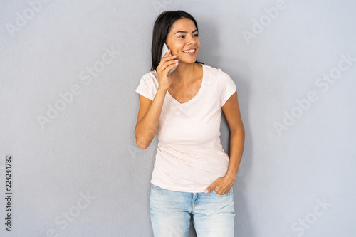 Happy woman talking on mobile phone on a white isolated background.