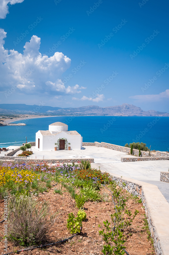 Traditional small whitewash Greek Orthodox Chapel on the edge of Aegean sea.