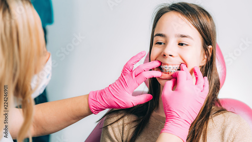 Orthodontist checking girl   s dental braces