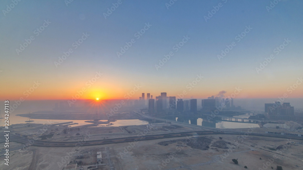 Fototapeta premium Abu Dhabi city skyline with skyscrapers at sunrise from above timelapse