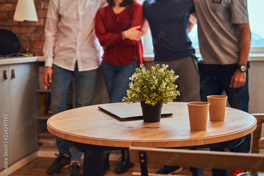 Cropped photo of a group of interracial students with laptop in a student dormitory. Cropped photo of a group of interracial students with laptop in a student dormitory.