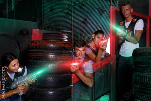 Group of  young friends playing laser tag  game  with laser guns © JackF