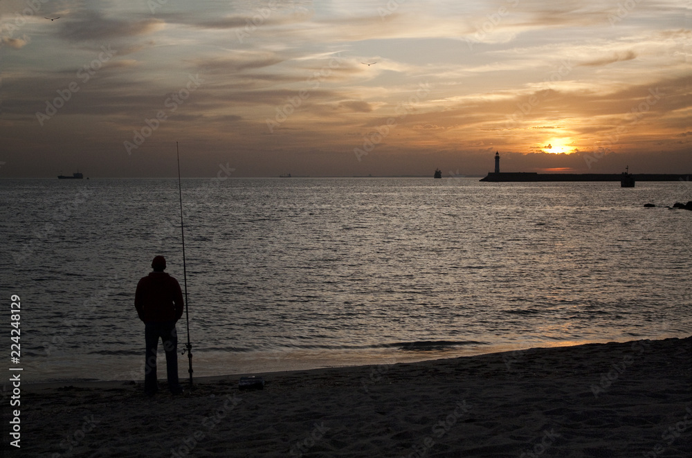 Silhouette of man fishing in the Mediterranean Sea at sunset. Photo taken in Almeria, Andalusia, Spain.