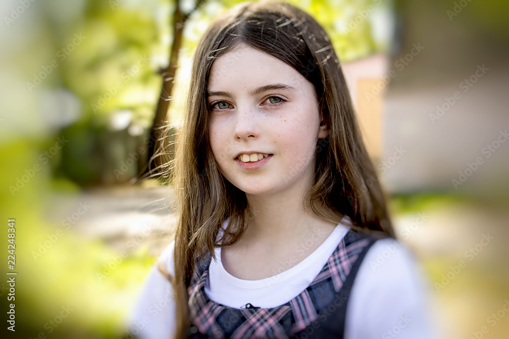 Portrait of a teenage girl, in strict clothing. The girl in the park Portrait of a teenage girl, in strict clothing. The girl in the park