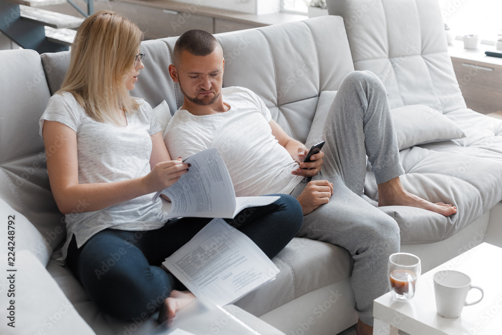 Man watching TV. Woman looking through documents. Lifestyle House Concept