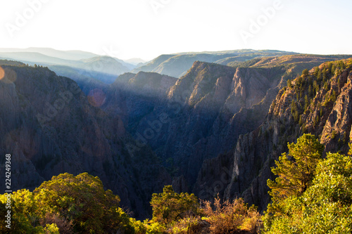 Early dawn light hits the upper cliff walls and bright autumn foliage at Black Canyon of the Gunnison National Park in Colorado © Martha Marks