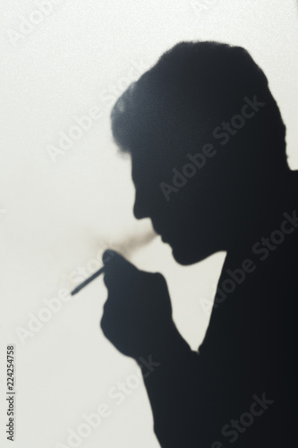 shadow of smoking man, young man smoking a cigarette, concept abstract background