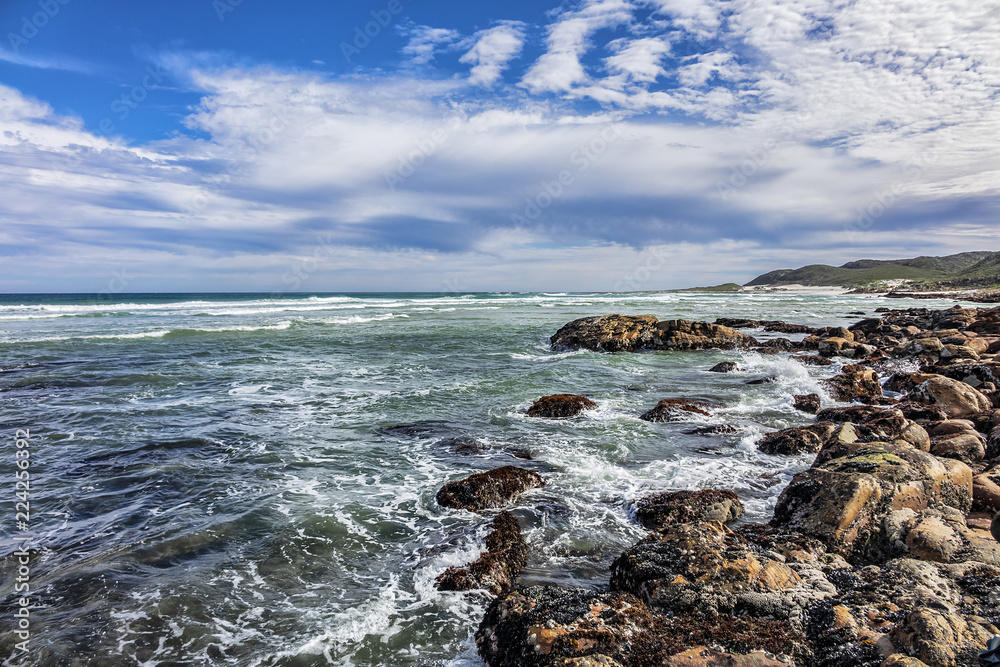 Picturesque view of the rocky shoreline of Atlantic Ocean and Platboom Beach. Platboom Bay is a beautiful beach along coastline nestled in Cape of Good Hope Nature reserve, Cape Town, South Africa.