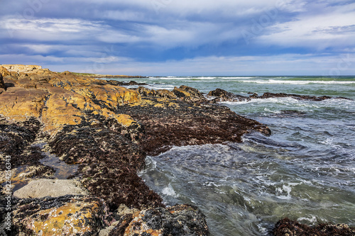 Picturesque view of the rocky shoreline of Atlantic Ocean and Platboom Beach. Platboom Bay is a beautiful beach along coastline nestled in Cape of Good Hope Nature reserve, Cape Town, South Africa.