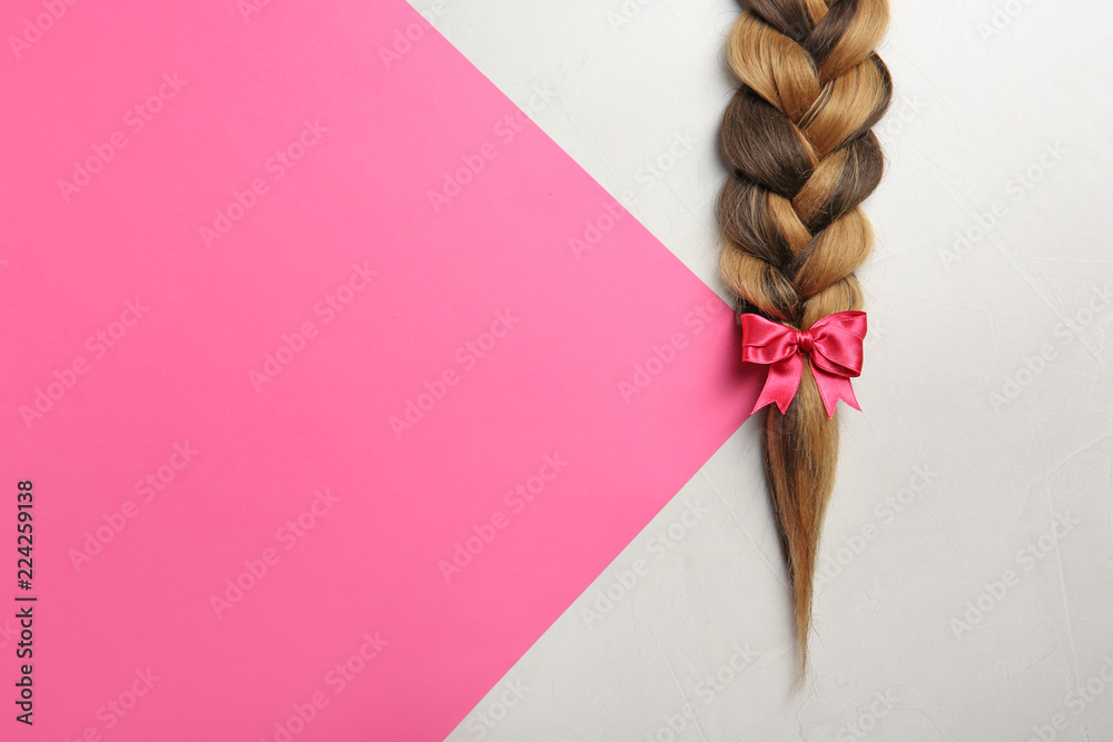 Braid and space for text on color background, top view. Healthy hair - obrazy, fototapety, plakaty 