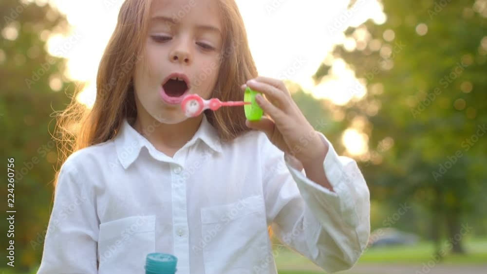 Beautiful girl in the evening park having fun and letting bubbles, children's games Beautiful girl in the evening park having fun and letting bubbles, children's games