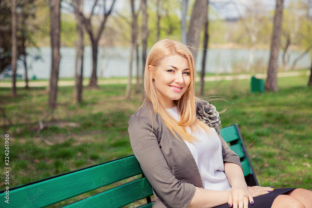 Beautiful woman sitting on bench outdoors Beautiful woman sitting on bench outdoors