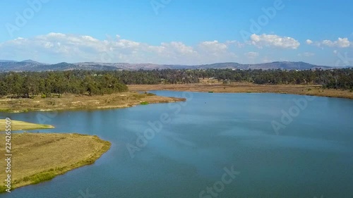 Drone footage moving straight up revealing Lake Dyer and surrounds, including mountains in the distance.