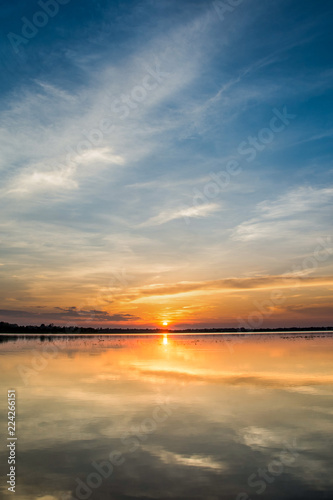 Sunset in the lake. beautiful sunset behind the clouds above the over lake landscape background. dramatic sky with cloud at sunset