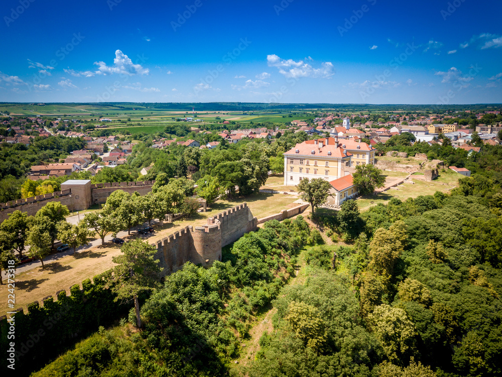 Aerial summer panorama of ruined Ilok castle on the Croatian Serbian border above the Danube river in Croatia with blue sky