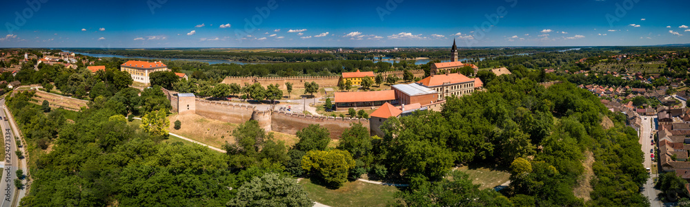 Aerial summer panorama of ruined Ilok castle on the Croatian Serbian border above the Danube river in Croatia with blue sky