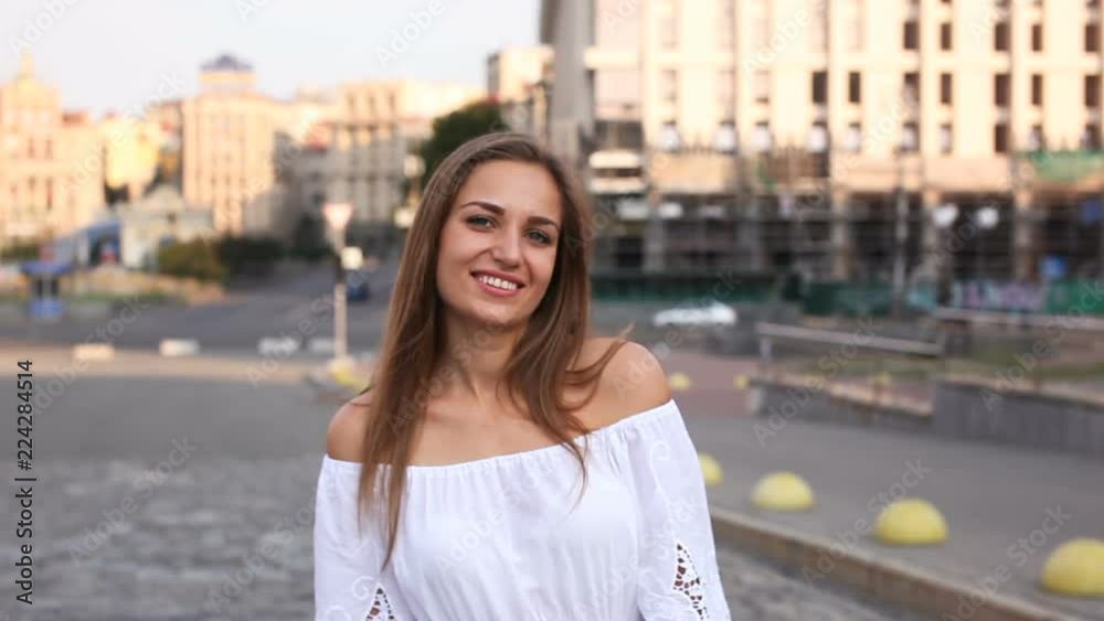 4 K. Young woman in white dress walk and smile in morning city street. Steady shot 4 K. Young woman in white dress walk and smile in morning city street. Steady shot