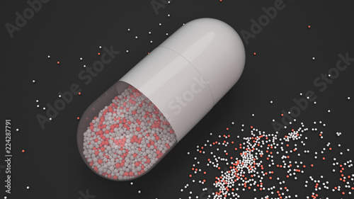 Capsule of colorful medicine on black background