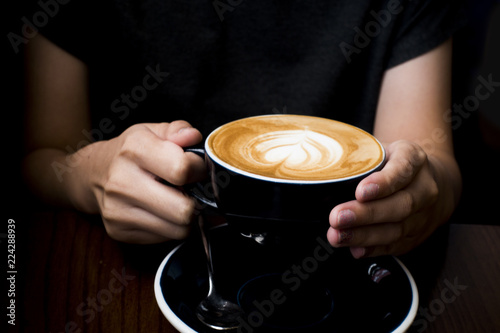 Coffee latte in her hand. Dark background