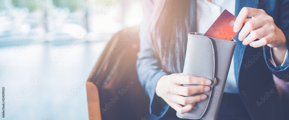 Business women hand Using a credit card, she pulled the card out of her wallet.Web banner.