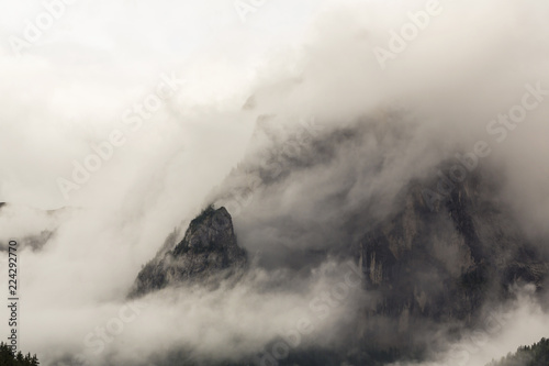 Dramatic sunset with rain clouds and rocky peaks in the Dolomite Alps, Italy, in summer