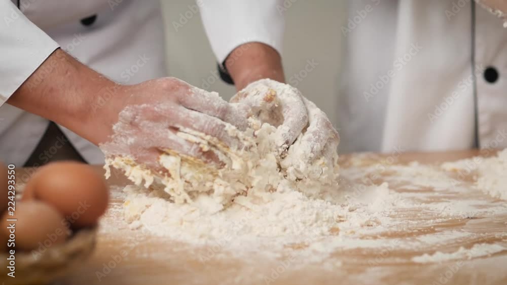 Chef hands preparing dough for pizza on table closeup Chef hands preparing dough for pizza on table closeup