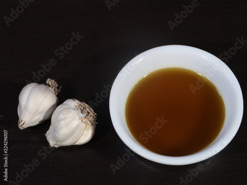 Garlic and Mustard Oil on Wooden Background, Mustard Oil on Wooden Background, Raw garlic on Wooden Background,Garlic and Mustard oil Used for All Type Body Pain,