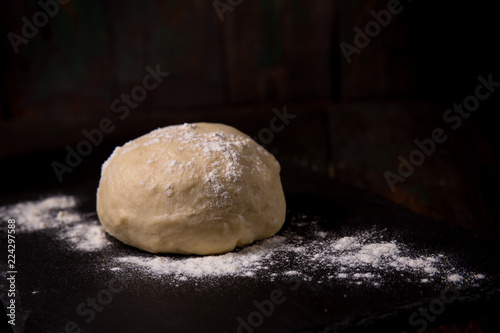 Dough with flour on a black board