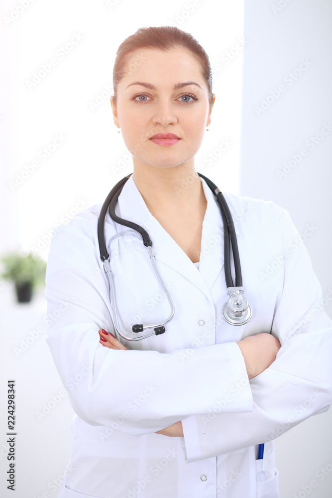 Brunette female doctor standing straight at hospital. Medicine and health care concept Brunette female doctor standing straight at hospital. Medicine and health care concept