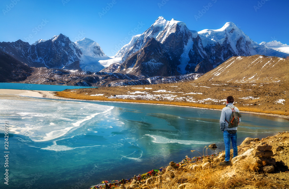 Male tourist enjoy scenic view of high altitude Gurudongmar lake at North Sikkim, India