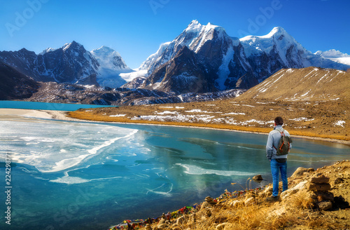 Male tourist enjoy scenic view of high altitude Gurudongmar lake at North Sikkim, India photo