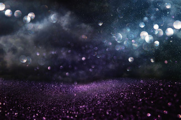 glitter vintage lights background. black, blue, purple and silver. de-focused.
