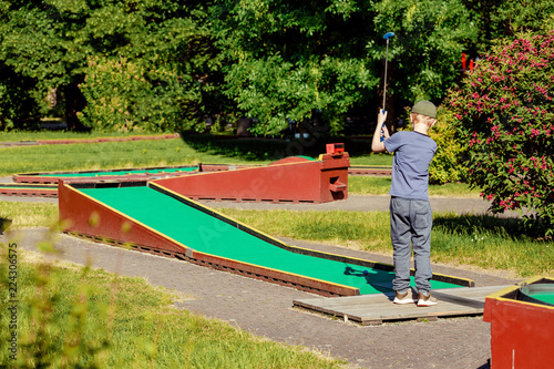 People playing mini adventure golf on a beautiful sunny summer day