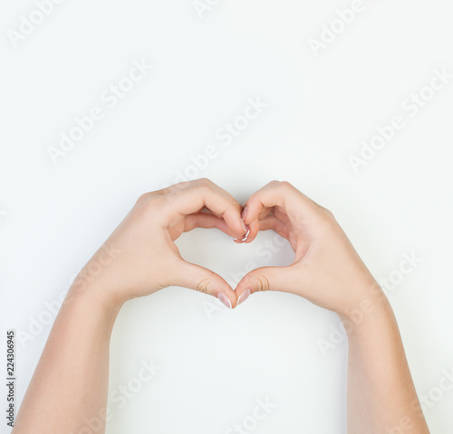 Female hands with heart shape on white background. Manicure concept