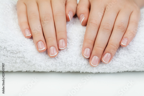 Beautiful female hands with white towel on white table
