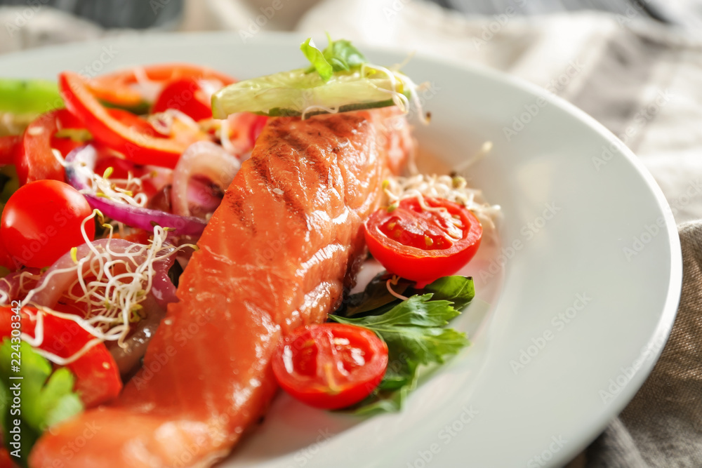 Tasty salmon with fresh salad on plate, closeup