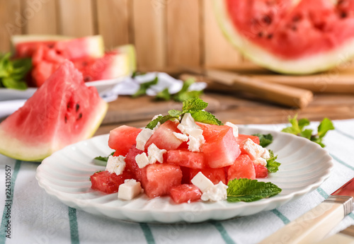 Plate with delicious watermelon salad on table