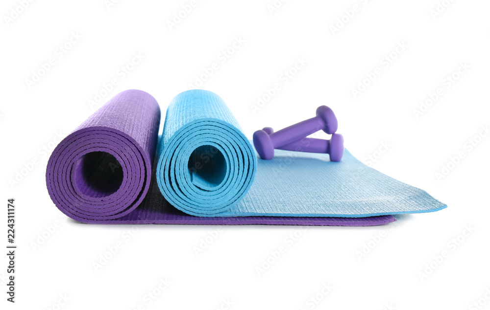 Different yoga mats with dumbbells on white background Different yoga mats with dumbbells on white background
