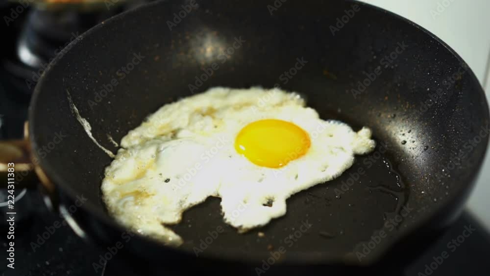 slow-motion of fried egg on pan slow-motion of fried egg on pan