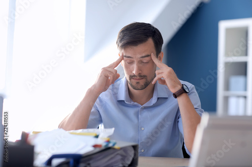 Tired businessman working in office