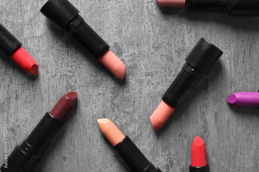 Fototapeta premium Different lipsticks on grey background, flat lay