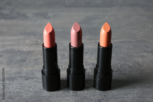 Different lipsticks on grey background photo