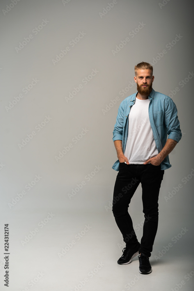 Full length portrait of a happy casual man standing isolated on a gray background. Full length portrait of a happy casual man standing isolated on a gray background.