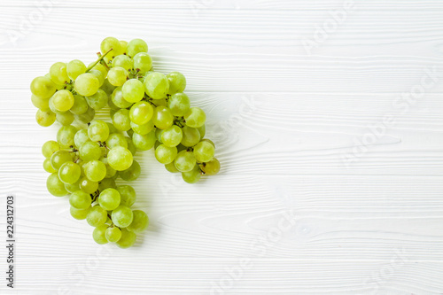 Ripe sweet grapes on white wooden background