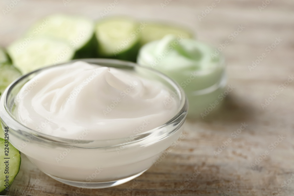 Bowl with cucumber body cream on wooden table, closeup Bowl with cucumber body cream on wooden table, closeup