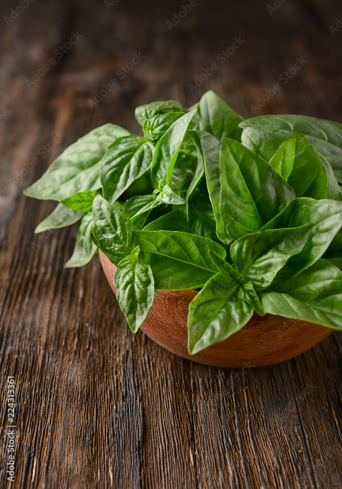 Bowl with fresh green basil on wooden table Bowl with fresh green basil on wooden table