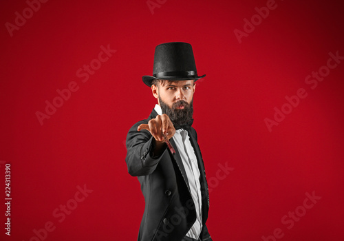 Male magician on color background