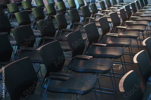 Several rows of empty plastic chairs in the audience prepared for the speaker s speech in front of students or journalists and spectators. 